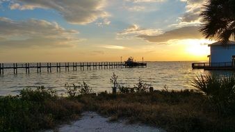 photo of a sailing boat near the harbor at sunset