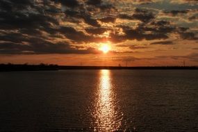 the sun in the evening sky over the lake