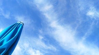 blue sky over blue beach umbrella