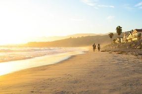 people walk along the beach in los angeles