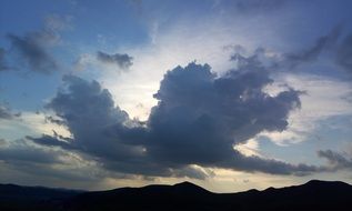 cumulus clouds over a mountain range