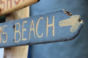 wooden road signpost to the beach