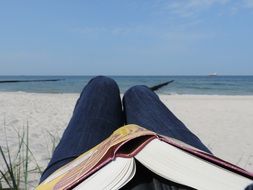 book on your knees, reading on the beach