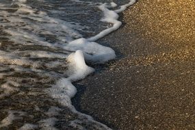 Foamy wave on dark Sand Beach