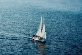 lonely sailing vessel in the blue water