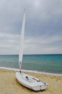 white sailing boat on a tropical shore