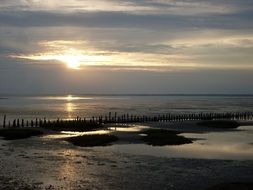 beach with wooden pier at dusk