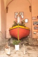 flowers and religious statue in a colorful decorative boat on the island of Corsica, France