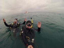 divers take pictures in the open ocean