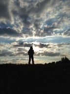 silhouette of a man against a cloudy evening sky