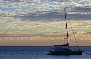 distant view of a yacht in the ocean at dusk