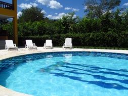 white sunbeds near the pool on a sunny day