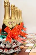 champagne bottles decorated with colorful sweets, bow ties and other decorations