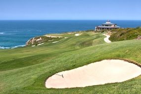 Landscape with the green golf resort on the water coast in summer