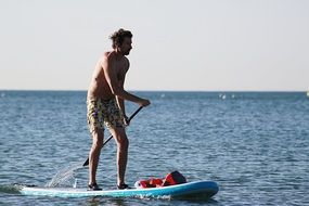 Photo of the sailboating man in shorts on a sea