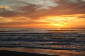 orange sunset in the clouds over the coast
