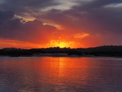 orange sunset in the clouds over the lake