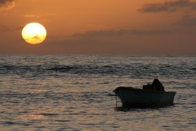 boat on the water against the setting sun