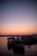 sunset over fishing boats in the harbor