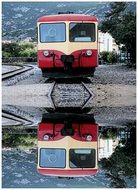 train and train reflection in a puddle
