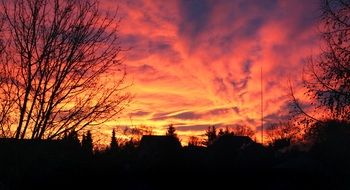 orange-red sunset over dark silhouettes