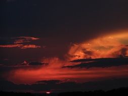 red-orange sunset in the clouds at dark dusk