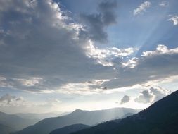 blue clouds above dark mountains