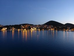 Lights of the city nea the water with the mountains
