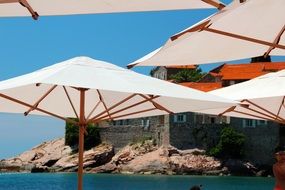 white beach umbrellas and castle on the coast