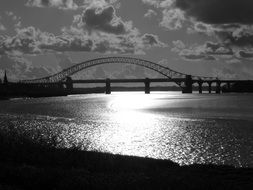 black and white photo of a large metal wash across the river