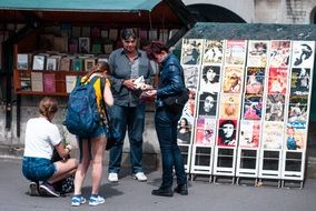 Tourists at stand with posters on street Market, france, Paris