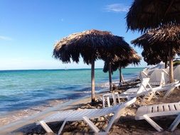 sun loungers under umbrellas on the beach in the Caribbean