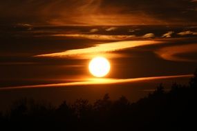 bright sun in the evening sky near the clouds