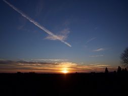 Beautiful sunset on the horizon and aircraft contrail in the sky