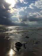 photo of the sun and thunderclouds over the evening beach