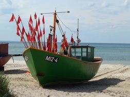 green fishing boat with red flags