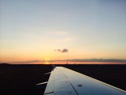 Aircraft Wing above land at Sunset