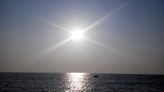 bright sun in the sky over the ocean