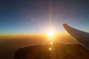 bright sun above an airplane wing