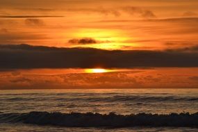 dark strip of clouds against a background of golden sunset