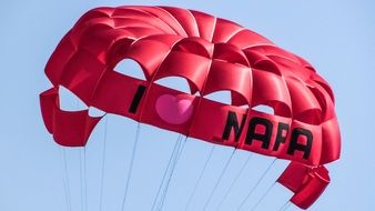 red parachute in the sky over cyprus