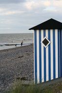beach hut with blue stripes and sea coast