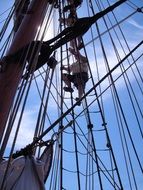 man crawling up the sailing ropes