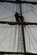 man on the mast of the sailboat