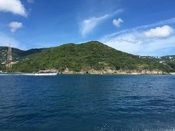 motor boat speeding along green coastline
