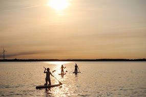People on the Stand Up Paddles in colorful sunshine