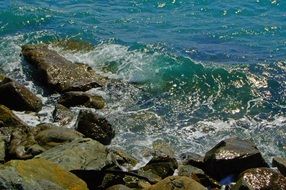 waves on coastal stone in bright sun