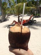 coconut cocktail on sandy beach background