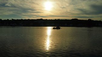 setting sun over the boat on the water