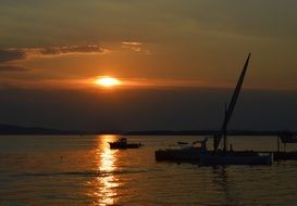 sunset in the clouds over a sailboat